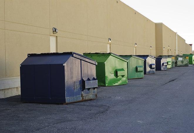 a waste management truck unloading into a construction dumpster in Banner, WY